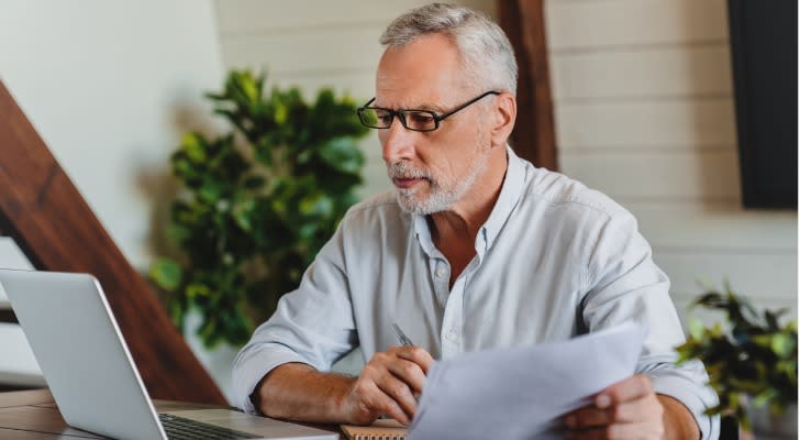 A man who's approaching retirement looks over his finances to estimate how much his taxes will be.