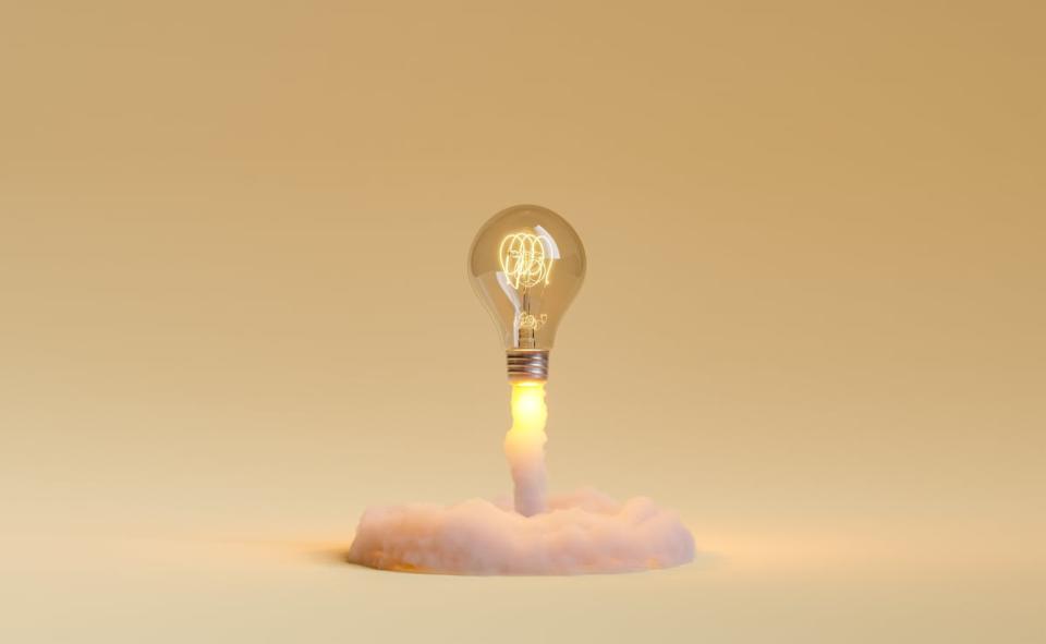 A lightbulb taking off like a rocket on a golden background.