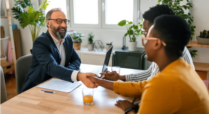 A financial advisor shakes hands with clients whom he's helping manage an inherited IRA. 