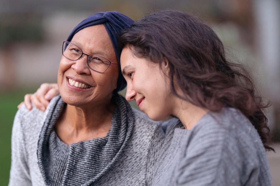 Two people smile and sit close.