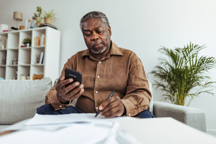 Senior adult man calculating how much he has paid on Social Security taxes.