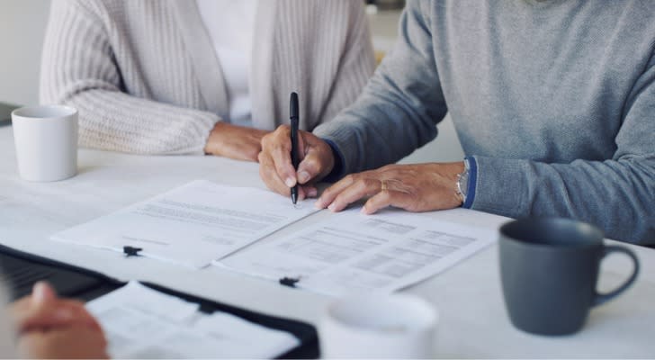 A couple signs a series of documents to finalize the trust they're creating for their family.