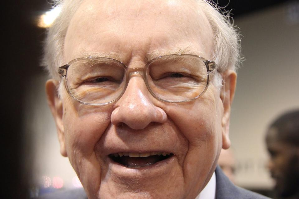 A jubilant Warren Buffett surrounded by people at Berkshire Hathaway's annual shareholder meeting.