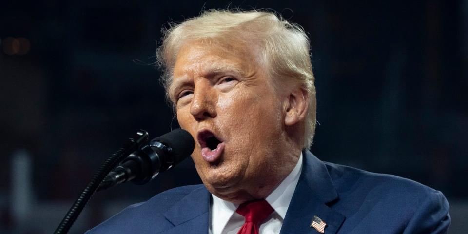 Former president Donald Trump speaks into a microphone while campaigning in Arizona.