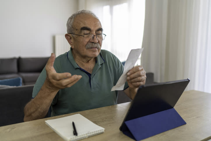 Senior man calculating Social Security taxes.