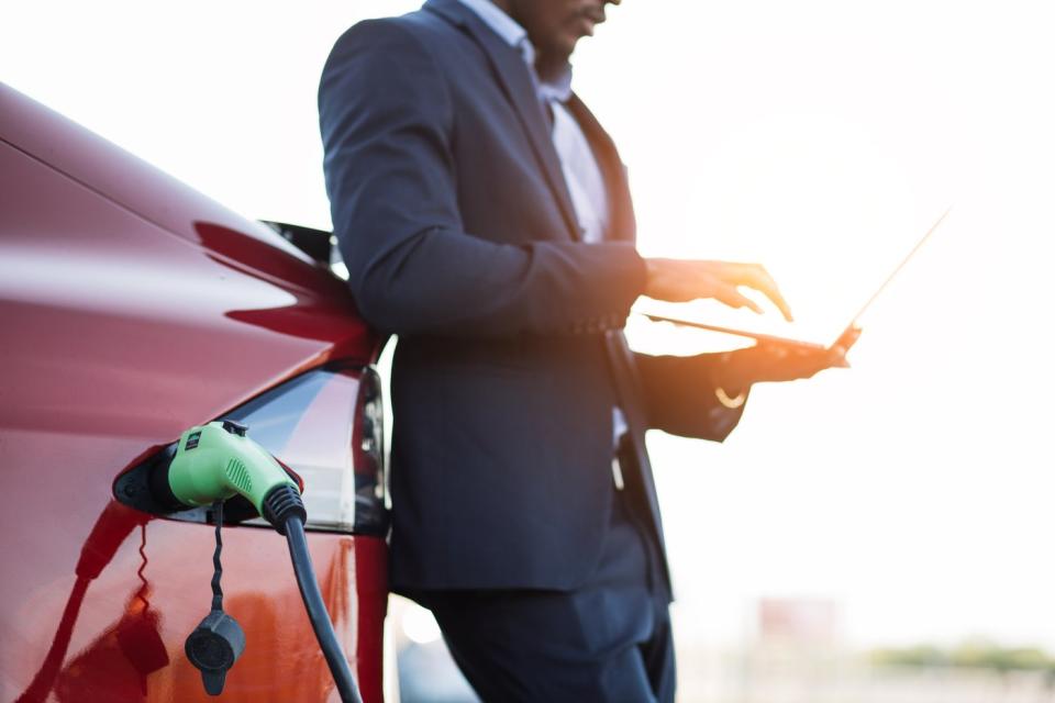 A person charging an electric vehicle.