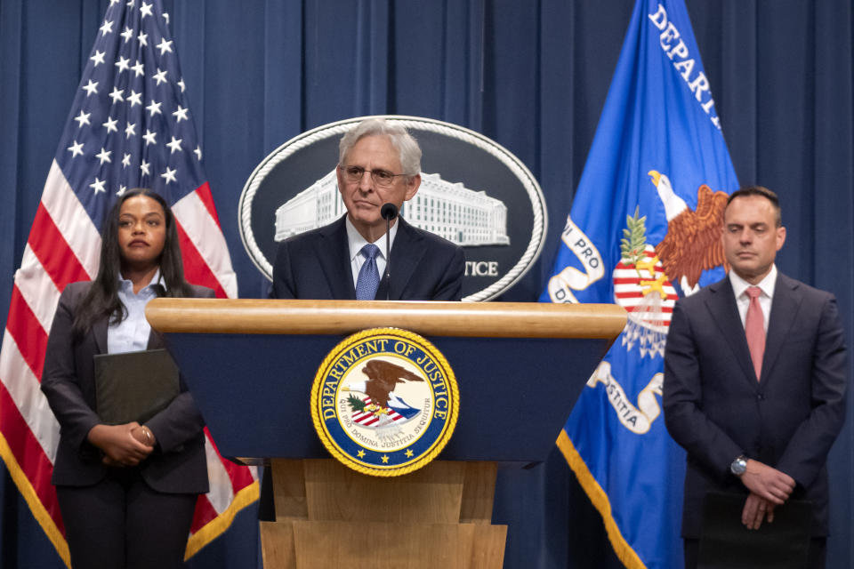 Attorney General Merrick Garland, center, is flanked by Principal Deputy Assistant Attorney General Doha Mekki, left, and Principal Deputy Associate Attorney General Benjamin Mizer, right, as he speaks during a news conference at the Department of Justice, Tuesday, Sept. 24, 2024, in Washington. (AP Photo/Mark Schiefelbein)