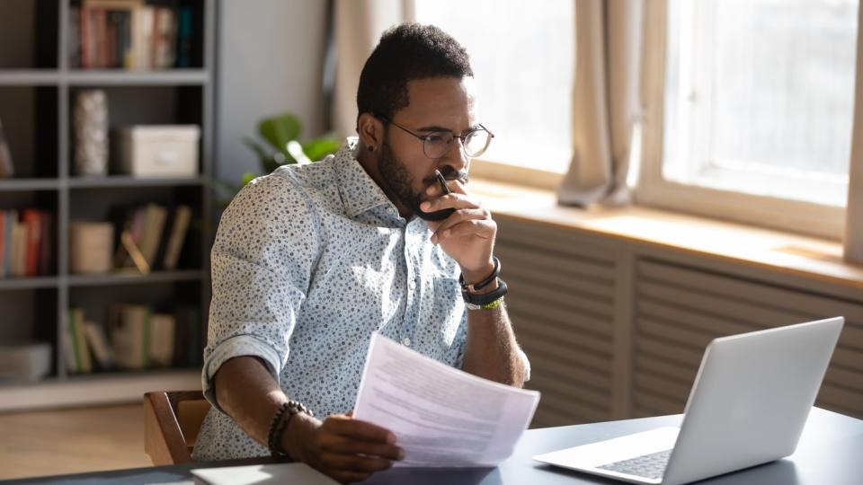 An investor looks pensively at something on a laptop.