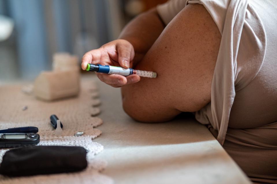 A person taking a GLP-1 injection.