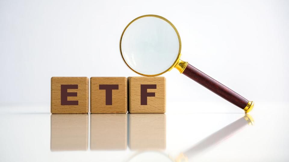 A magnifying glass laying on top of blocks with the letters E T F.