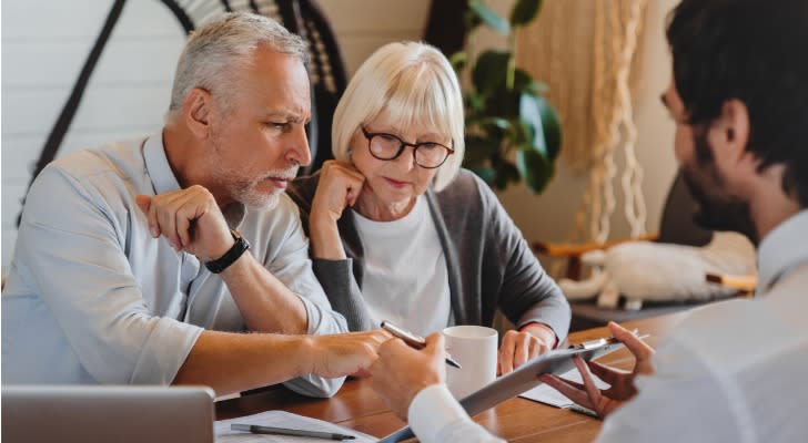 A couple who's approaching retirement meets with their financial advisor to determine if they can retire at 65.