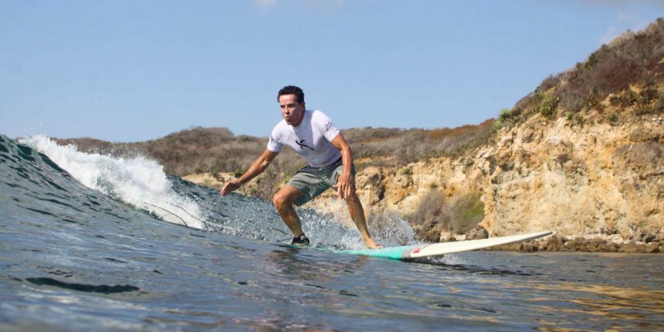 Summit Therapeutics CEO Bob Duggan shown surfing a wave.