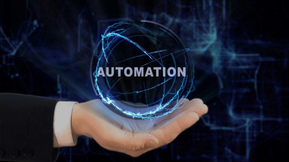 A hand holding a sphere that says automation. 