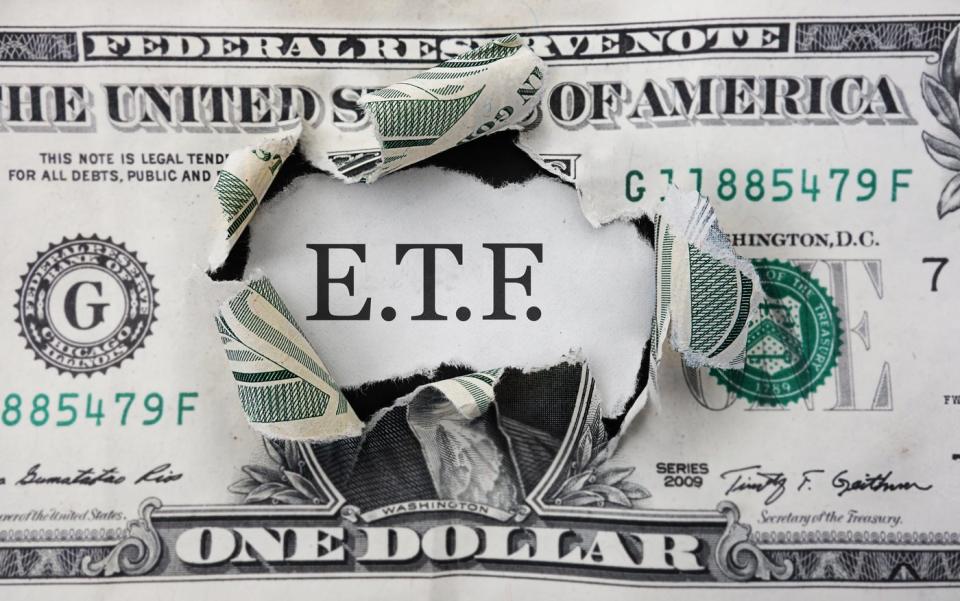 The letters to "E.T.F." in a hole in a dollar bill.