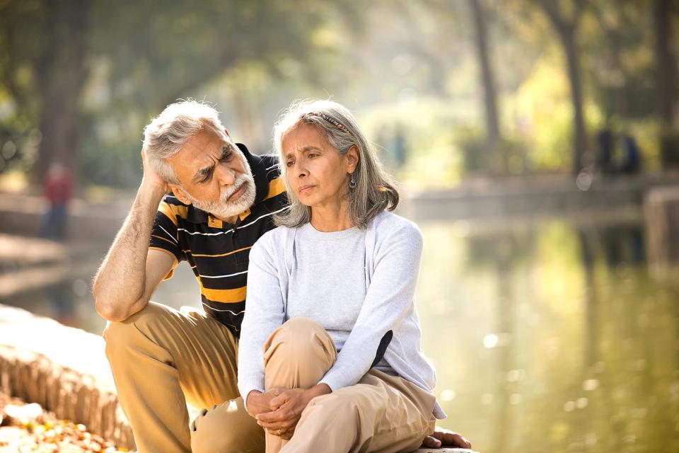 Two people with serious expressions sitting outside.