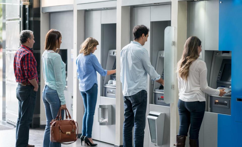 People withdrawing money at an ATM.