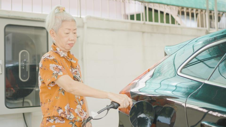 A person plugging their electric vehicle into a charging station.