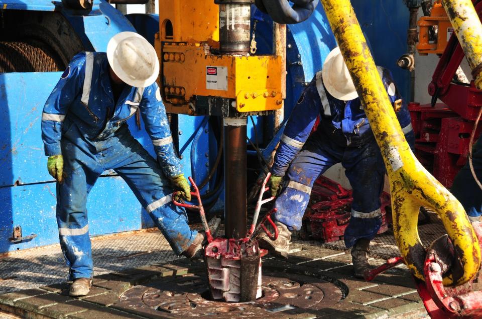 Oil rig employees working on a drilling platform. 