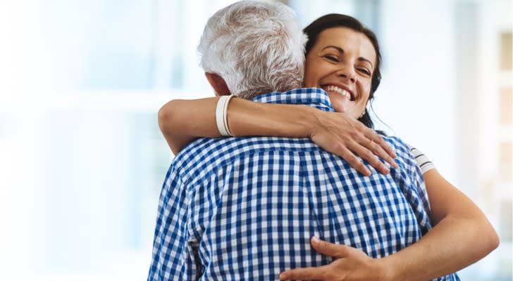 A woman hugs her father after receiving a $50,000 gift to be put toward her down payment on a home.