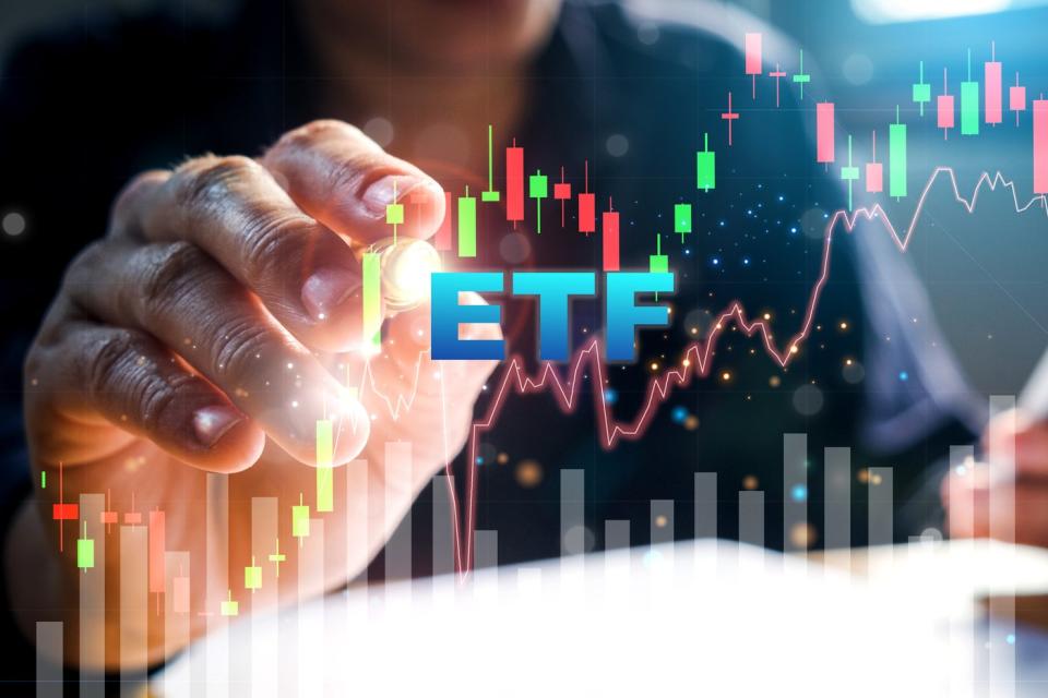 A hand pointing to a stock chart with "ETF" displayed in front of the chart.