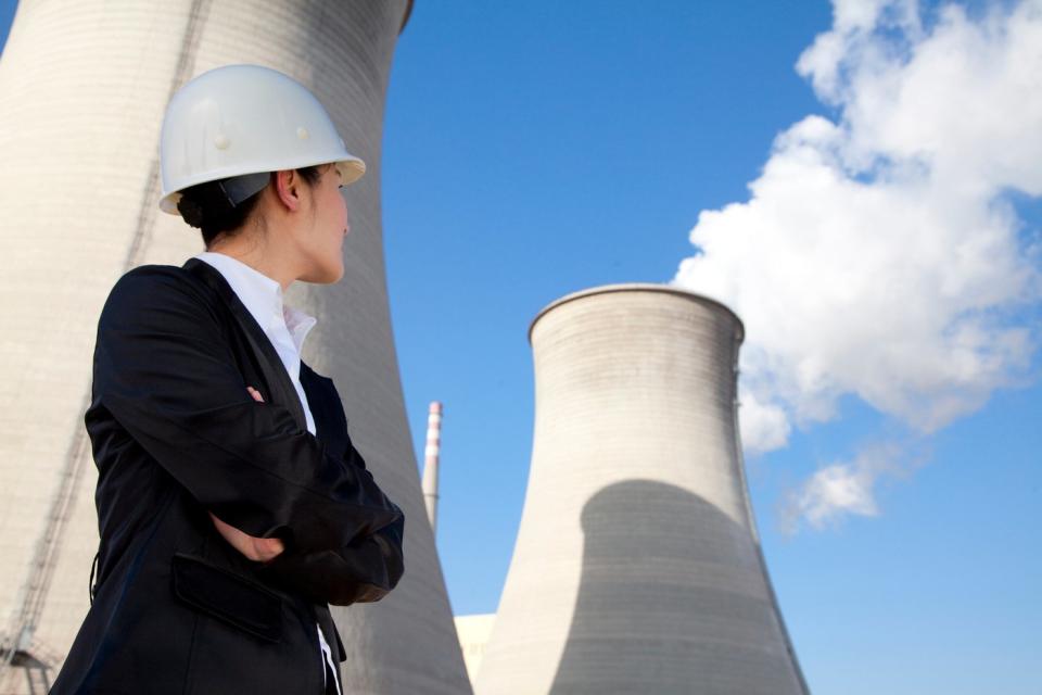 A person standing in front of a nuclear power plant.