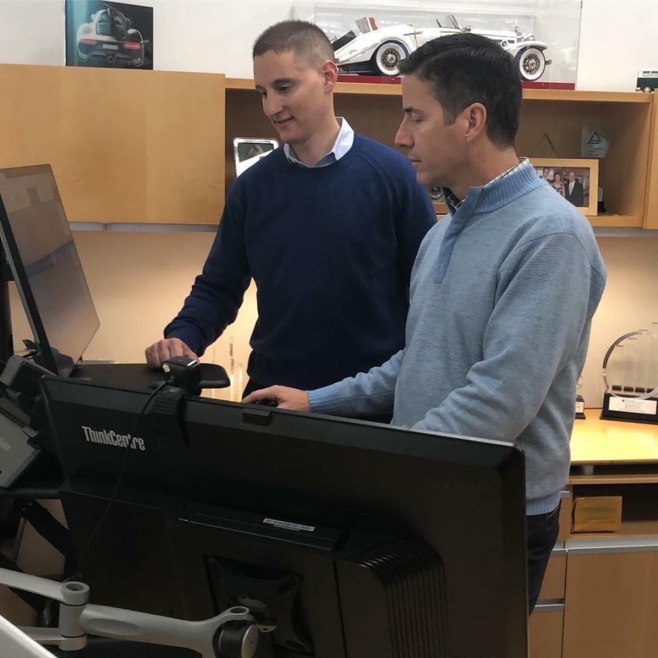 Ohio car dealer Bernie Moreno works with Ohio Treasurer Josh Mandel, left, to pay some state business taxes with Bitcoin in November 2018.